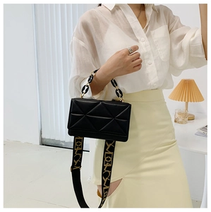 Detail of black quilted leather crossbody bag with chain handle and jacquard strap