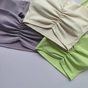Close-up of ruched detail and soft matte fabric on sporty halter bras in various colors