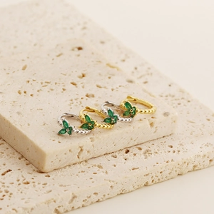 Close-up of S925 silver and gold butterfly hoop earrings with green emerald gemstones