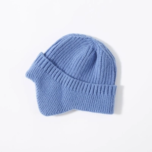 Detail view of the soft knitted texture and ear protection on this blue winter beanie