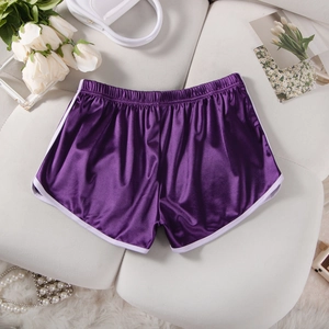 Flat lay of purple satin athletic shorts with white trim on a white decorative background