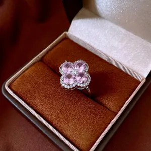 Elegant four-leaf clover ring with pink heart zircons in a brown velvet jewelry box