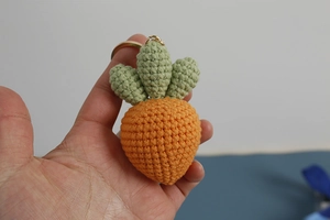 Handmade crochet orange carrot keychain charm with green leaves and gold metal ring hook