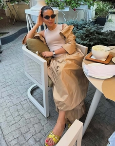 Detailed outdoor view of a chic three-piece lounge set with high-waist joggers and gold heels