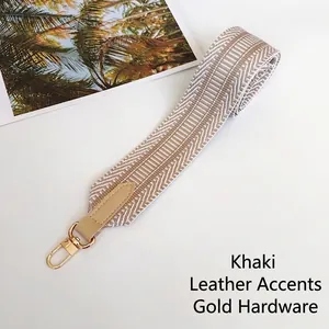 Detail of khaki geometric woven strap with gold metal hooks and leather connectors