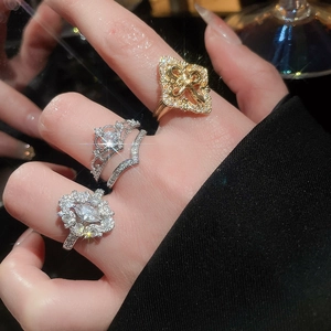 Macro view of court style zircon flower rings and silver crown stacked rings on hand