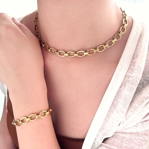 Detailed view of 18k gold plated geometric cross chain necklace and bracelet set