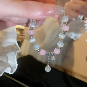 Detailed close-up of beaded star bracelet featuring pink beads and cat eye stones