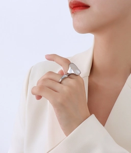 Detail of silver irregular geometric ring with white shell inlay worn by model
