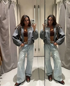 Selfie miroir montrant un blouson aviateur gris zippé avec un jean taille haute large