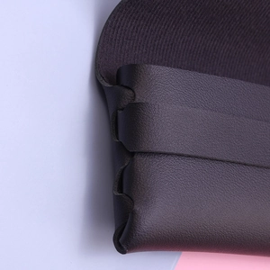 Macro shot of black leather eyewear case featuring unique hand-woven side seam details