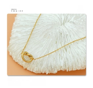 Detail of 18K gold plated titanium steel necklace with a minimalist knot heart pendant