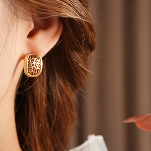 Gros plan détaillé sur une boucle d'oreille dorée à motif léopard sur le modèle