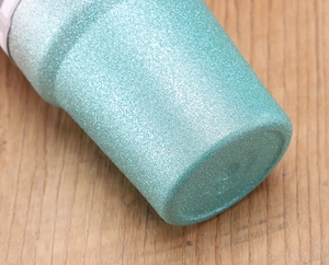 Macro detail of turquoise glitter texture on the bottom of the stainless steel tumbler
