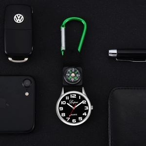 Detail view of quartz clip-on watch with compass and green aluminum buckle on black nylon
