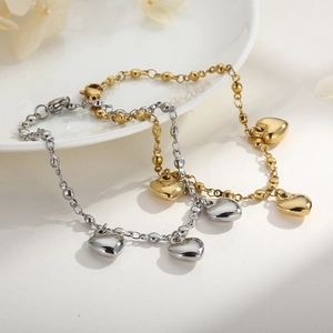 Minimalist stainless steel heart bracelets in gold and silver finish on a white plate