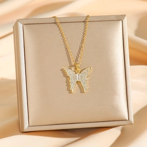 Elegant gold-plated butterfly pendant necklace with zircon crystals on champagne satin