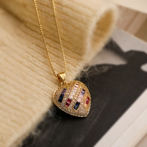 Elegant gold plated heart pendant necklace with colorful gems on knit sweater