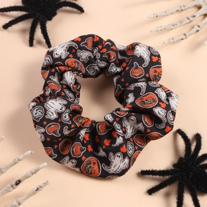 Macro detail of Halloween scrunchie with pumpkin and ghost prints on black fabric