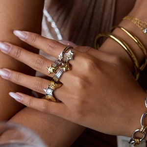 Detail of model wearing a star-shaped stacked ring with gold and silver zircon accents