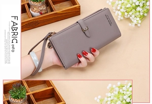 Close-up of grey long wallet featuring pebbled texture and detachable wrist strap