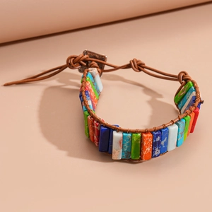 Detail of woven leather bracelet with colorful rectangular natural stones and metal buckle