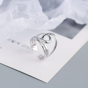 Macro detail of silver adjustable S925 ring with layered wire and knot design