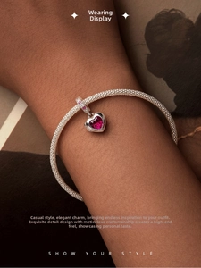 Close-up of a S925 silver mesh bracelet with a heart-shaped pink gemstone pendant