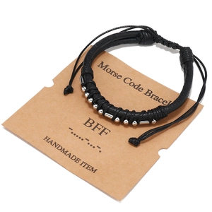 Dettaglio del bracciale BFF in codice Morse con perline d'argento su carta