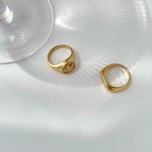 Detail of vintage gold angel relief signet ring and rectangular ring set with soft shadows