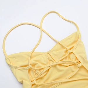 Détail des fines bretelles croisées dans le dos d'une robe longue jaune moulante