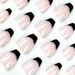 Short coffin press on nails featuring nude base and black French tips on white background