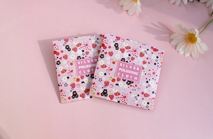 Close-up of pink floral paper packaging for silver polishing cloth with daisy decor