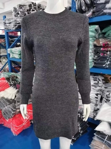 Dettaglio dell'abito in maglia grigio scuro con trama a coste verticali e scollo rotondo