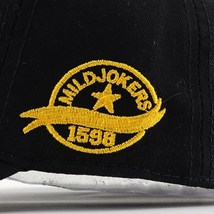 Gros plan détaillé de la broderie dorée MILD JOKERS sur une casquette en coton noir