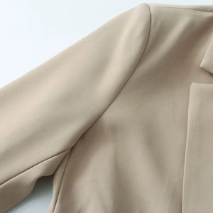Close-up of khaki blazer showing fine fabric texture and collar seam detail