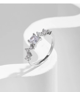 Detail of s925 silver ring with sparkling square zircon stones on white background