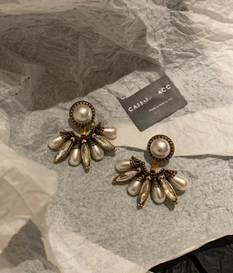 Détail macro de boucles d'oreilles vintage en éventail avec perles et cristaux