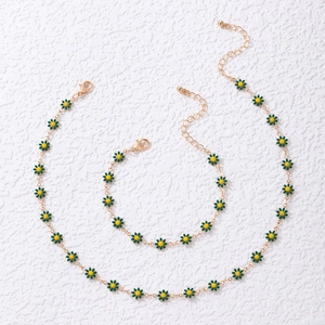 Golden daisy flower jewelry set with necklace and bracelet featuring green petals