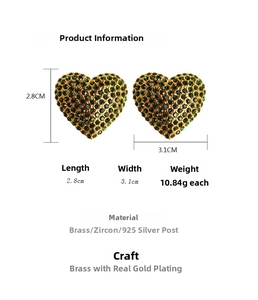 Détail de boucles d'oreilles cœur serties de zircons verts sur laiton doré