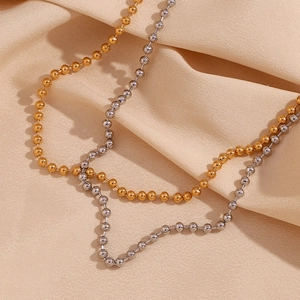 Minimalist 18K gold and silver 4mm bead ball chain necklaces on beige fabric