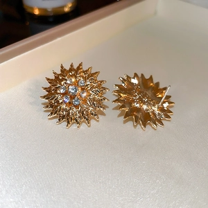 Vue macro de boucles d'oreilles tournesol dorées avec détails de strass scintillants