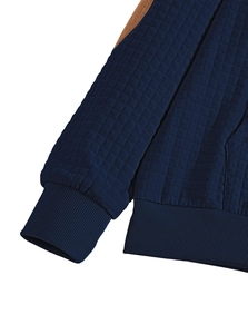 Detail of dark blue waffle knit fabric with ribbed cuffs and brown shoulder patches