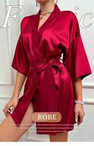 Detail of silk-like satin robe in deep red with V-neckline and elegant waist tie