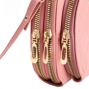 Detail of pink crossbody bag with triple metal zippers and quilted diamond texture