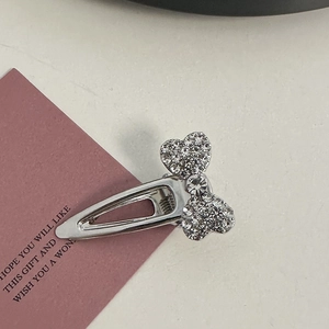 Detailed view of silver alloy hair clips with pink rhinestones, bow and heart designs