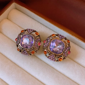 Macro shot of vintage style earrings with purple square stone and crystals in a velvet box