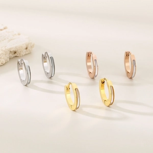 Macro detail of polished stainless steel hoops with white shell inlay in three colors