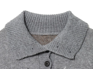Dettaglio maglione grigio a maglia verticale con colletto a costine e bottoni neri