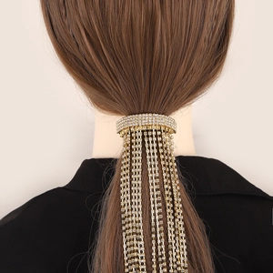 Detail of elegant gold ponytail clip with long sparkling rhinestone tassels on hair